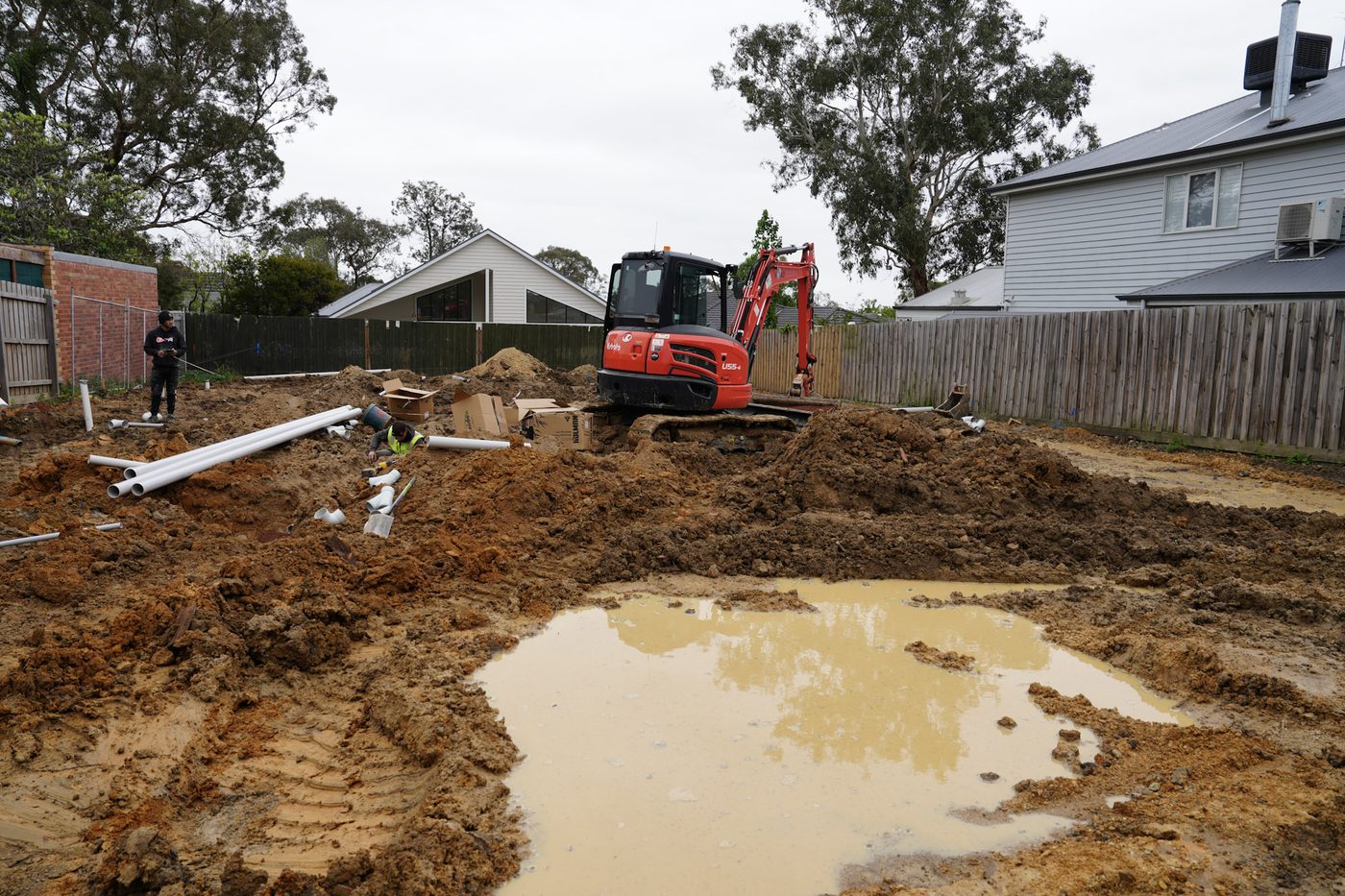 Crew working a wet trench during a drainage install.